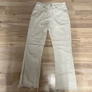 Cream AGOLDE jeans in “Vintage Flare”. Hems have been cut off.